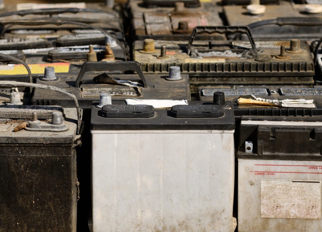 A pallet holds several batteries awaiting recycling at a metal recycling scrap yard